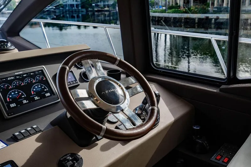 Slide: The Image of Steering wheel and dashboard of 2015 Azimut Fly 50 yacht, featuring modern controls. - 87