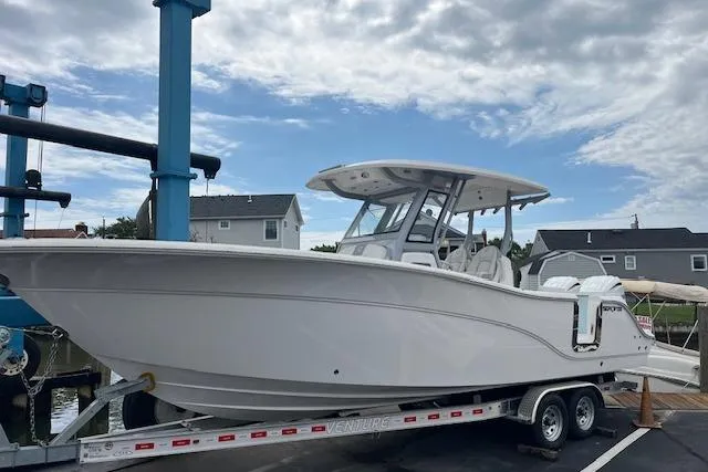 The Image of 2025 Sea Fox 288 Commander boat on trailer at marina under cloudy sky. - 1