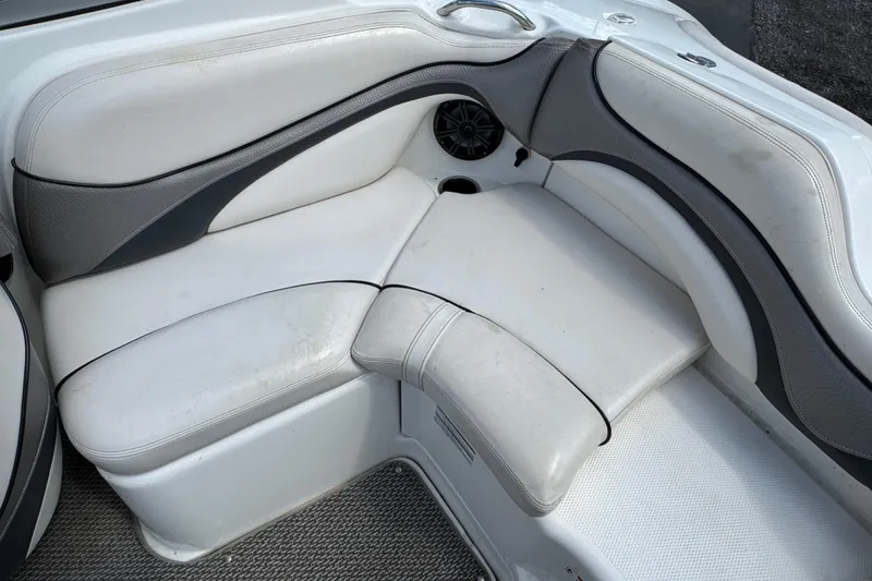 Slide: The Image of 2008 Yamaha Boats 212X interior seating with white and gray upholstery, featuring a speaker. - 10