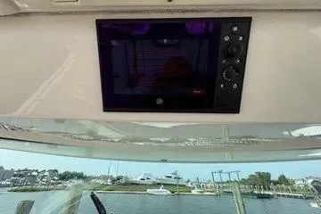 Slide: The Image of 2021 Tiara Yachts 38 LS dashboard with control panel, marina view in background. - 15