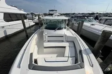 Slide: The Image of 2021 Tiara Yachts 38 LS luxury boat docked at marina, showcasing sleek design. - 17