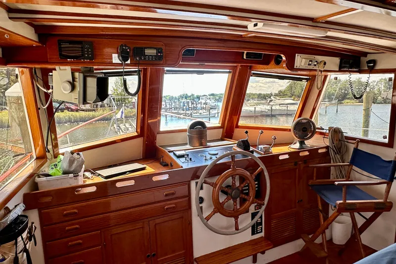 Slide: The Image of 1983 Kadey-Krogen Krogen 42 Trawler helm with wooden wheel, overlooking marina. - 13