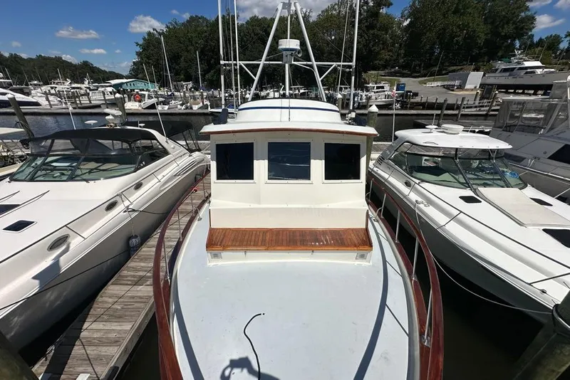 Slide: The Image of 1983 Kadey-Krogen Krogen 42 Trawler docked between two boats at a marina. - 5