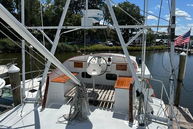 Slide: The Image of 1983 Kadey-Krogen Krogen 42 Trawler docked, featuring helm and American flag. - 8