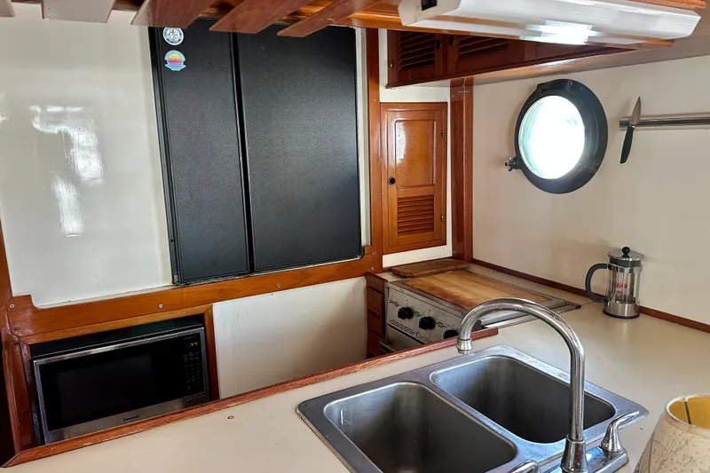 Slide: The Image of 1983 Kadey-Krogen Krogen 42 Trawler kitchen with sink, stove, and porthole window. - 27