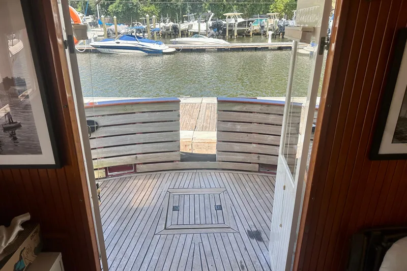 Slide: The Image of 1983 Kadey-Krogen Krogen 42 Trawler aft deck view with marina backdrop. - 29