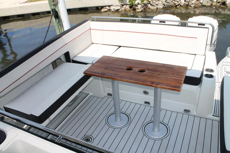 Slide: The Image of 2021 Jeanneau Leader 10.5 boat interior with seating and wooden table. - 13