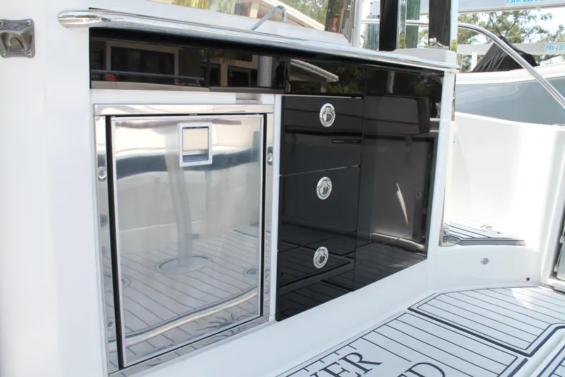Slide: The Image of 2021 Jeanneau Leader 10.5 boat interior with sleek cabinetry and stainless steel accents. - 22
