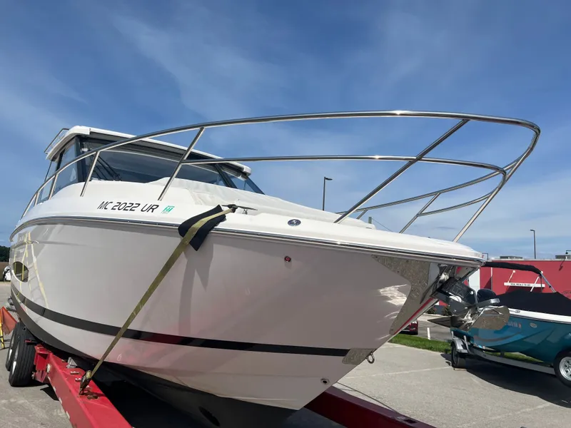 The Image of 2022 Regal 36GC boat on trailer outside a warehouse under a cloudy sky. - 0