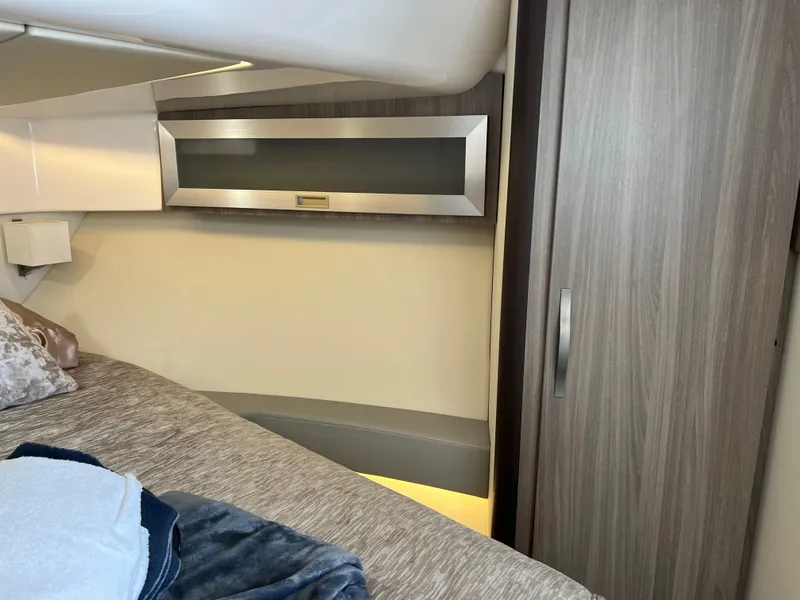 Slide: The Image of 2022 Regal 36GC boat on trailer under cloudy sky near warehouse. - 2