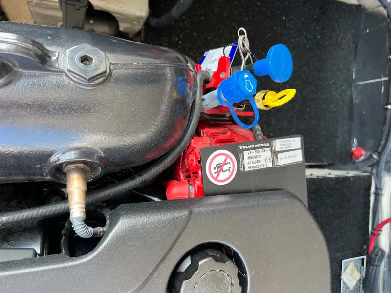 Slide: The Image of 2022 Regal 36GC boat deck with sunpad, docked near other boats and a red vehicle. - 21