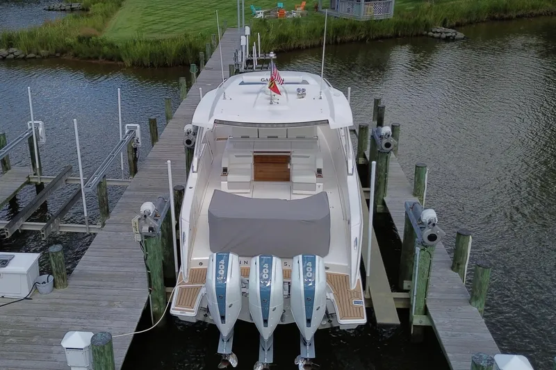 Slide: The Image of 2024 Tiara Yachts 38 LS docked with triple outboard engines, rear view. - 10