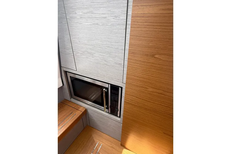 Slide: The Image of 2024 Tiara Yachts 38 LS interior with built-in microwave and wood paneling. - 19