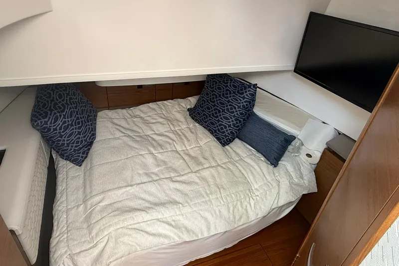 Slide: The Image of 2024 Tiara Yachts 38 LS cabin interior with bed, pillows, and TV. - 20