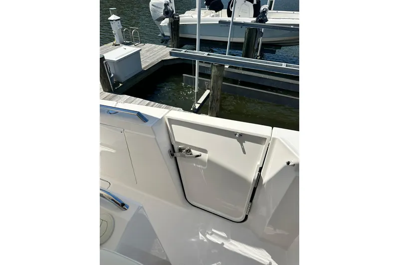 Slide: The Image of 2024 Tiara Yachts 38 LS boat docked, featuring a sleek white exterior and access door. - 24