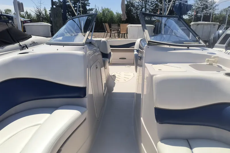 Slide: The Image of 2005 Tahoe 254 boat interior with white and blue seating, open deck, and windshield. - 10