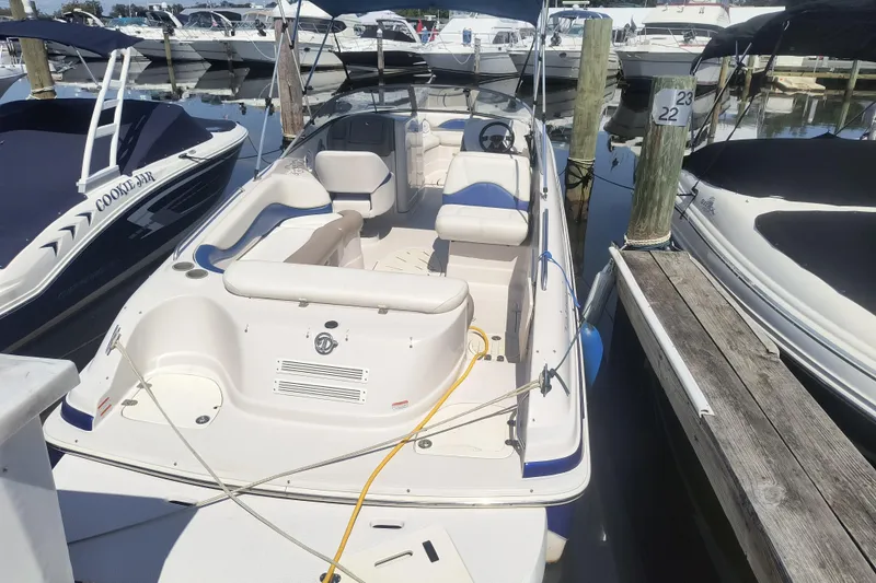 Slide: The Image of 2005 Tahoe 254 boat docked at marina, surrounded by other boats. - 4