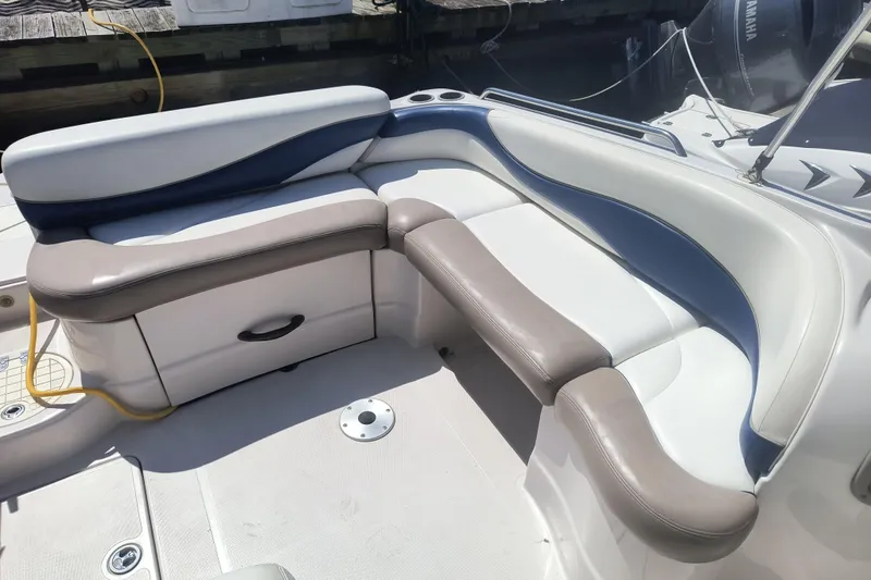 Slide: The Image of 2005 Tahoe 254 boat interior with cushioned seating and storage compartment. - 6
