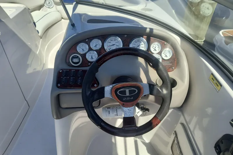 Slide: The Image of Steering wheel and dashboard of a 2005 Tahoe 254 boat, featuring gauges and controls. - 9