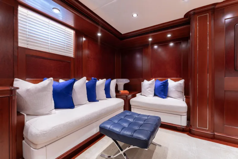 Slide: The Image of Luxurious yacht interior with plush seating, blue and white cushions, and rich wood paneling. - 19