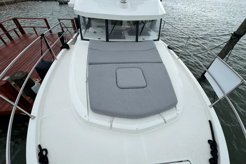 Slide: The Image of 2023 Beneteau Swift Trawler 35 with cushioned deck, docked by the water. - 13
