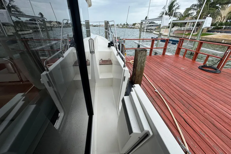 Slide: The Image of 2023 Beneteau Swift Trawler 35 docked, showcasing sleek design and spacious deck area. - 16