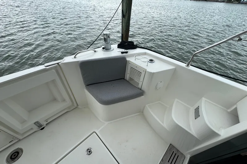 Slide: The Image of 2023 Beneteau Swift Trawler 35 cockpit with seating, steps, and water view. - 18
