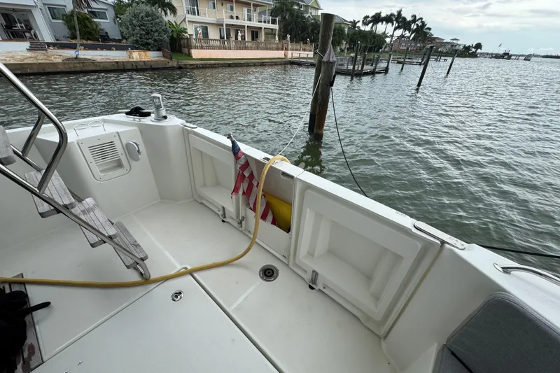 Slide: The Image of 2023 Beneteau Swift Trawler 35 docked, showcasing spacious deck and waterfront view. - 19