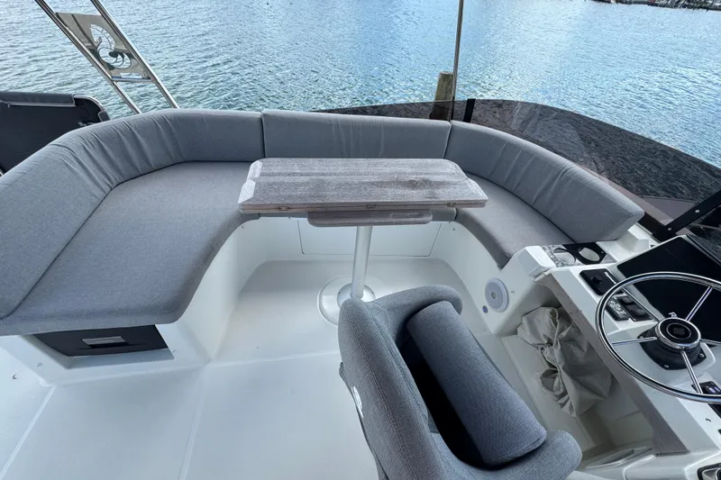 Slide: The Image of 2023 Beneteau Swift Trawler 35 cockpit with seating and steering wheel, overlooking water. - 23