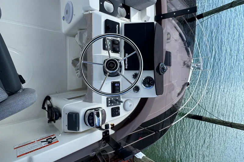 Slide: The Image of 2023 Beneteau Swift Trawler 35 helm with steering wheel and control panel. - 24