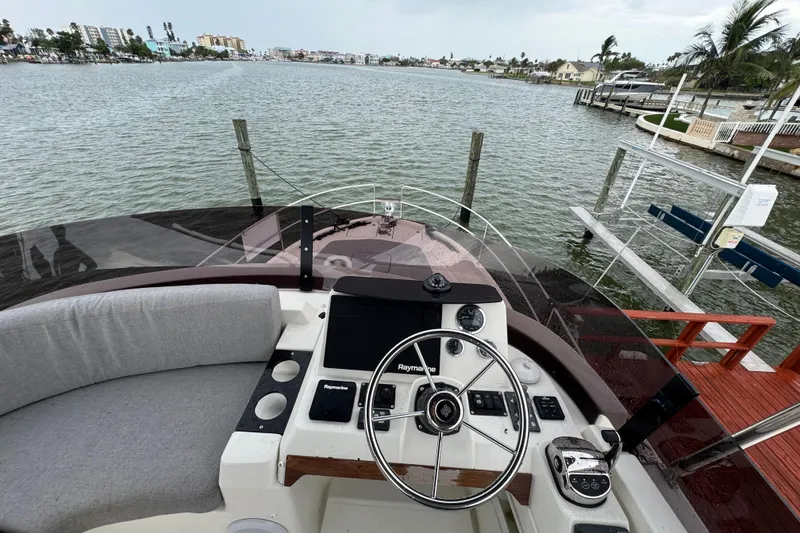 Slide: The Image of 2023 Beneteau Swift Trawler 35 helm with waterfront view, showcasing modern navigation equipment. - 25