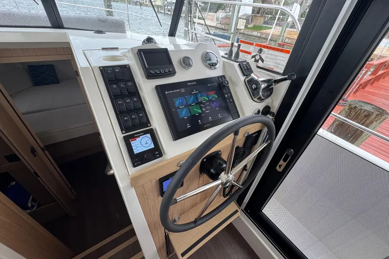 Slide: The Image of 2023 Beneteau Swift Trawler 35 helm with modern navigation controls and steering wheel. - 33