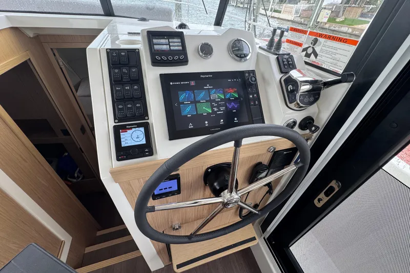 Slide: The Image of 2023 Beneteau Swift Trawler 35 helm with advanced navigation controls and touchscreen display. - 36