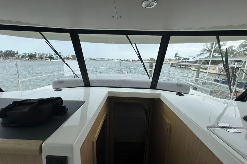 Slide: The Image of Interior view of 2023 Beneteau Swift Trawler 35, showcasing helm and waterfront scenery. - 38