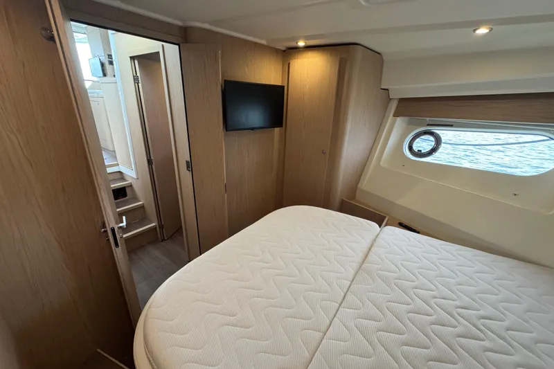 Slide: The Image of Interior of 2023 Beneteau Swift Trawler 35, featuring cozy bedroom with window view. - 40
