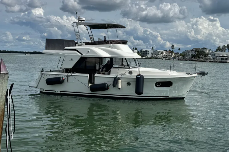 Slide: The Image of 2023 Beneteau Swift Trawler 35 cruising on calm waters under cloudy skies. - 45