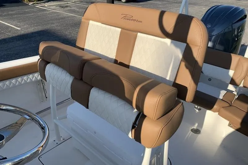 Slide: The Image of 2026 Pioneer ISLANDER 202 boat interior with tan and white seating, steering wheel visible. - 11