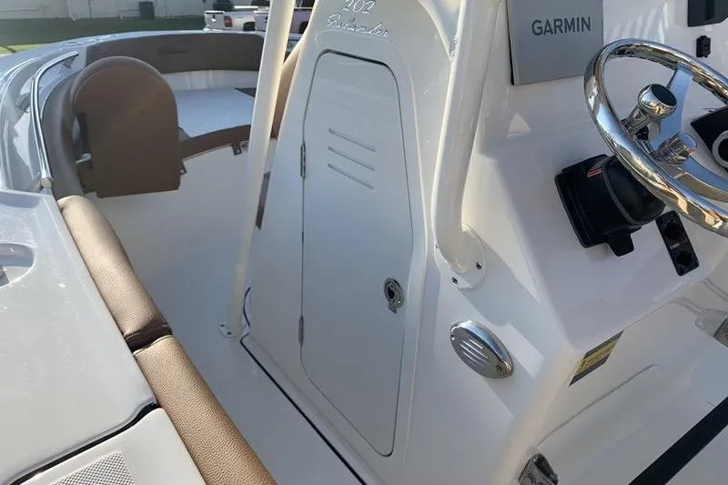 Slide: The Image of 2026 Pioneer ISLANDER 202 boat interior with Garmin navigation and seating area. - 22