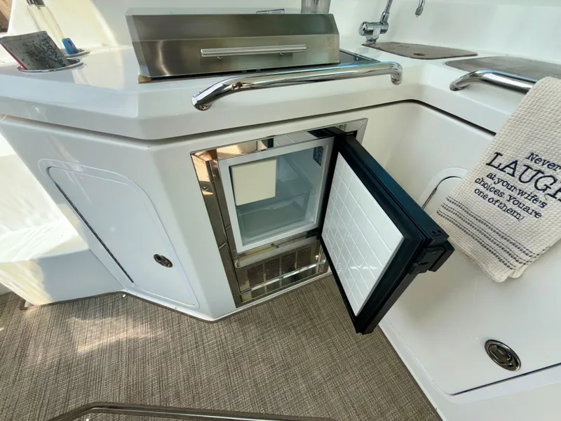 Slide: The Image of 2009 Cruisers Yachts 420 Coupe interior with open mini fridge and towel. - 10