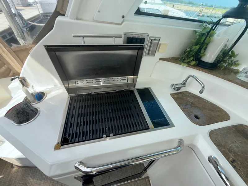 Slide: The Image of Outdoor grill and sink on 2009 Cruisers Yachts 420 Coupe, featuring sleek design and modern amenities. - 11