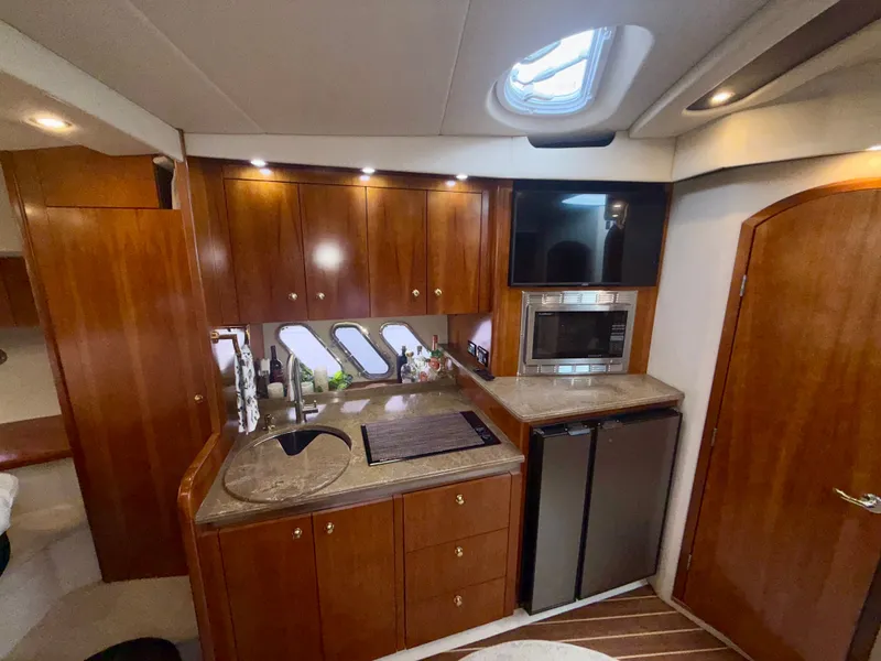 Slide: The Image of Luxurious 2009 Cruisers Yachts 420 Coupe kitchen with wood cabinetry and modern appliances. - 27