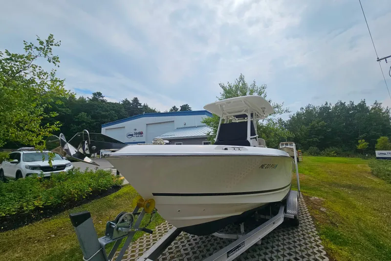 Slide: The Image of 2019 Boston Whaler 230 Outrage boat on trailer, parked outdoors near a building. - 23