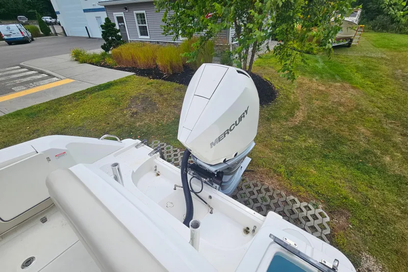 Slide: The Image of 2019 Boston Whaler 230 Outrage with Mercury outboard engine, parked on grassy area. - 5