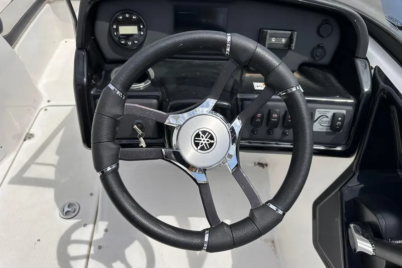 Slide: The Image of 2024 Yamaha AR195 boat steering wheel and dashboard controls. - 16