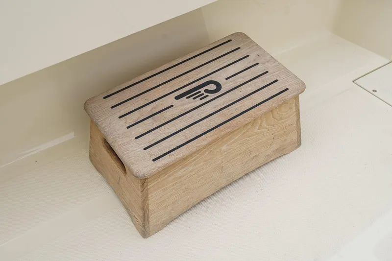 Slide: The Image of Wooden step with logo on a 2014 Hinckley Talaria 34 boat interior. - 10
