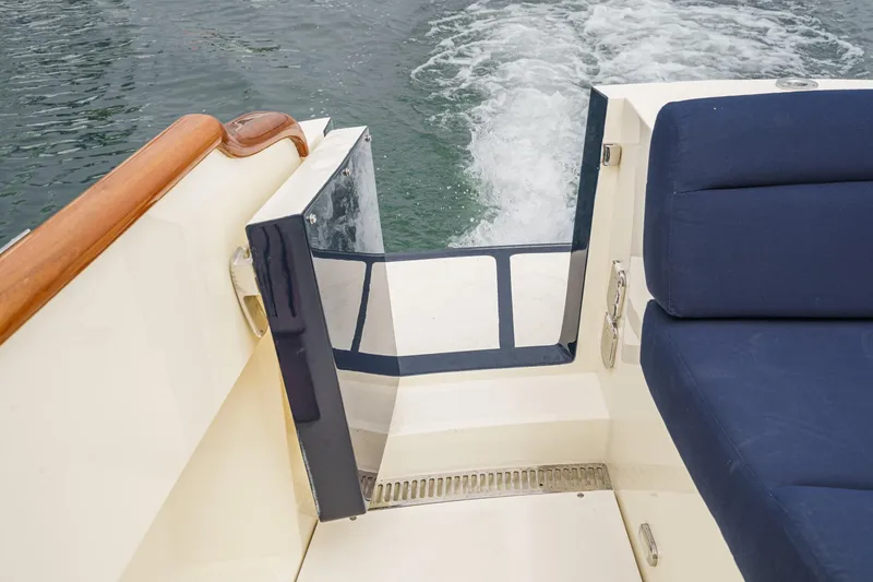Slide: The Image of 2014 Hinckley Talaria 34 boat interior with blue seating and open transom door. - 11