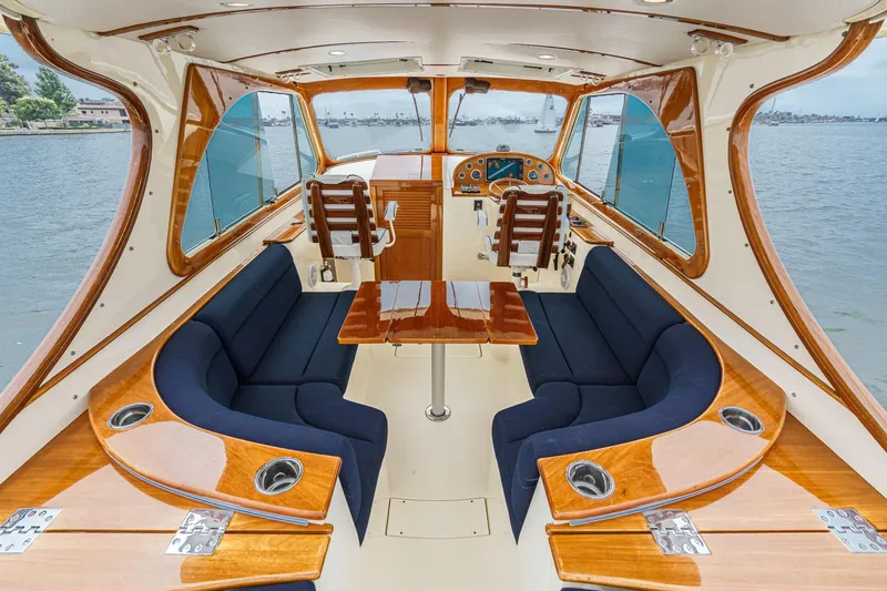 Slide: The Image of 2014 Hinckley Talaria 34 interior with elegant wood finish and navy seating. - 13