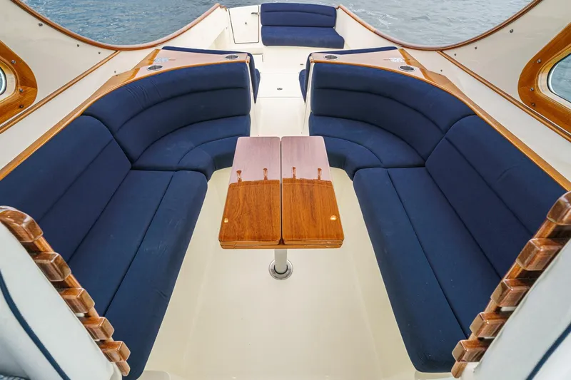 Slide: The Image of Interior of 2014 Hinckley Talaria 34 with blue seating and wooden table. - 16