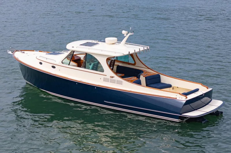 Slide: The Image of 2014 Hinckley Talaria 34 yacht on calm water, featuring sleek design and luxurious seating. - 2