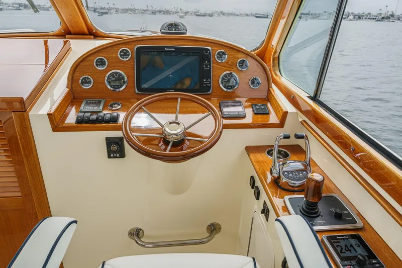 Slide: The Image of 2014 Hinckley Talaria 34 helm with wooden dashboard and modern navigation equipment. - 20